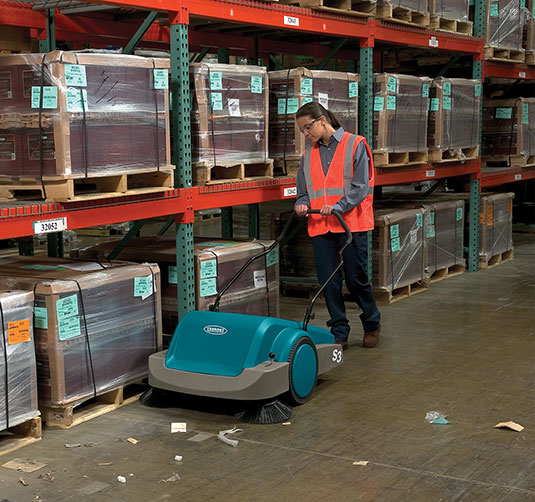 S3 Manual Sweeper being used in a warehouse.